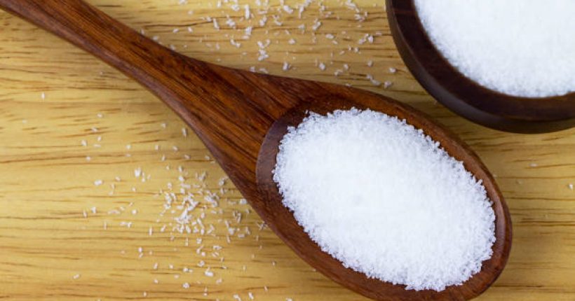 Monosodium glutamate in wooden spoon on wooden plate. MSG a flavour inhancer of many Thai food and asian food.